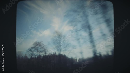 Driving through forest road in winter, with beautiful clear blue sky in the background. Vintage Film Look. 