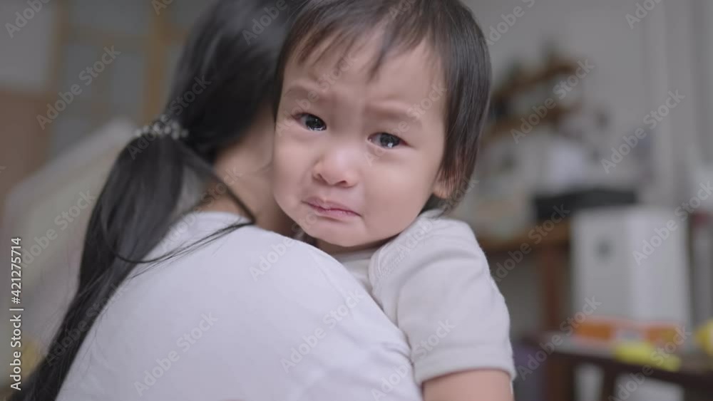 Portrait of young mother consoling an adorable crying daughter, black hair mother gently stroking her daughter's back to comfort, motherhood everyday life, children stay safe home, warm and tenderness Portrait of young mother consoling an adorable crying daughter, black hair mother gently stroking her daughter's back to comfort, motherhood everyday life, children stay safe home, warm and tenderness