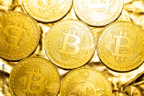 Golden bitcoin Coins on a golden background. Trading on the cryptocurrency exchange. Cryptocurrency Stock Market Concept. Virtual money concept. Mining or blockchain technology. Business concept.