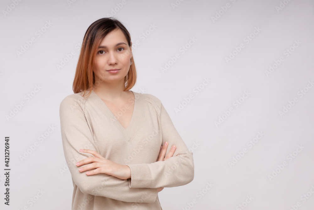 Beautiful woman stands with her arms crossed on her chest on a white background Beautiful woman stands with her arms crossed on her chest on a white background