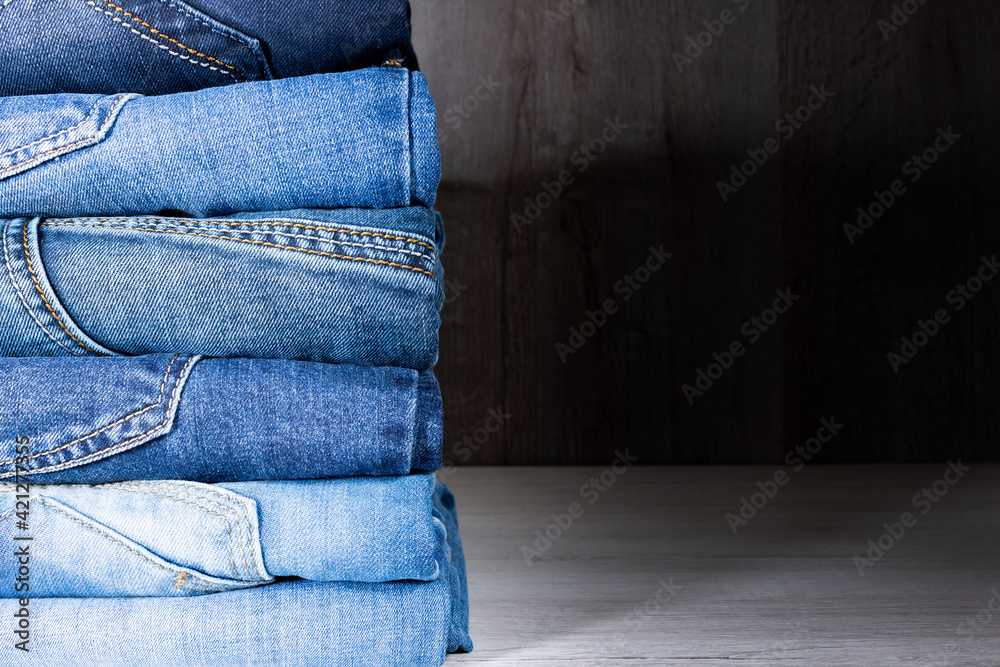 Neatly folded denim clothing. Background on the theme of jeans. Neatly folded denim clothing. Background on the theme of jeans.