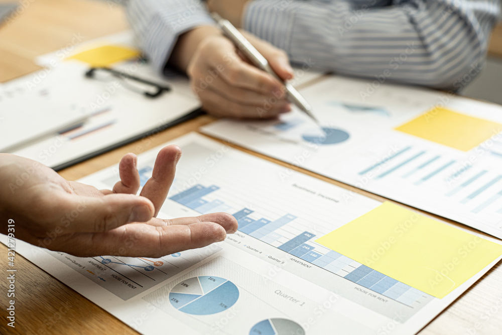 Two businessmen are meeting together on company finances, on a table where there is a paperwork for meetings, meetings and plans together for the company to thrive. The concept of corporate finance. Two businessmen are meeting together on company finances, on a table where there is a paperwork for meetings, meetings and plans together for the company to thrive. The concept of corporate finance.