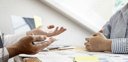 The male employee is explaining information from the company's financial documents to the manager after the document has been prepared for the manager to bring to the meeting with the management.