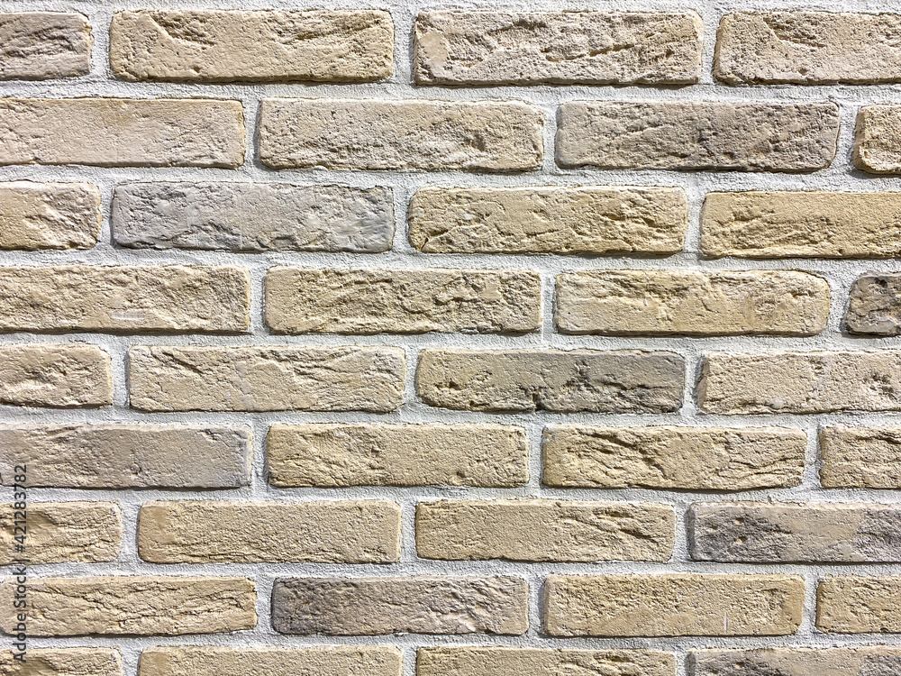 Fototapeta premium old beige brick wall, decorative tiles brick by brick