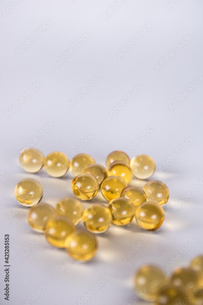 Many yellow vitamins lie isolated on a white background. Fish oil for health Many yellow vitamins lie isolated on a white background. Fish oil for health