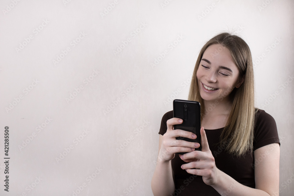 A fair-haired beautiful girl blogger confidently uses the phone and, with a smile, broadcasts live to subscribers on social networks. Social media coaching. A fair-haired beautiful girl blogger confidently uses the phone and, with a smile, broadcasts live to subscribers on social networks. Social media coaching.