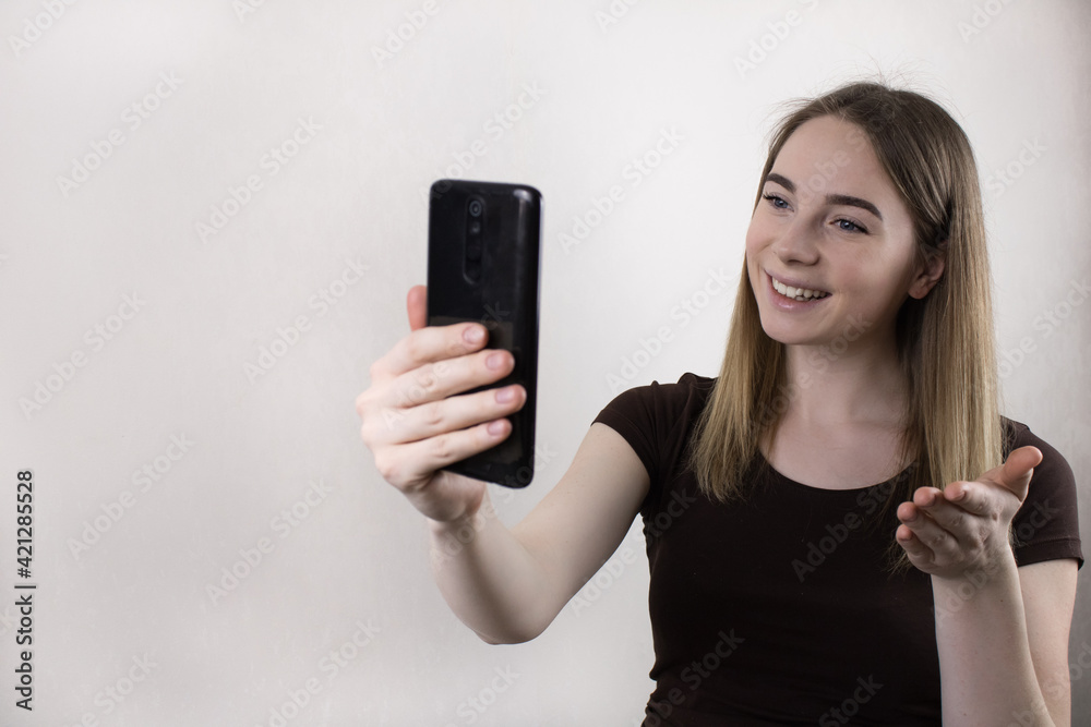 A blonde beautiful girl blogger confidently and with a smile conducts a live broadcast to subscribers on social networks. Social media coaching. A blonde beautiful girl blogger confidently and with a smile conducts a live broadcast to subscribers on social networks. Social media coaching.