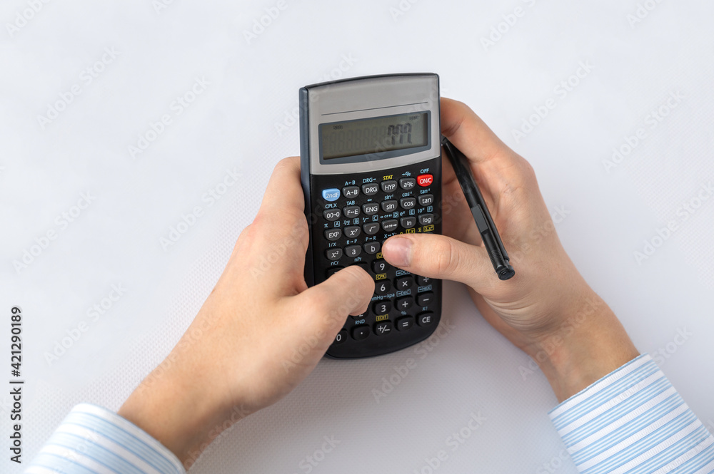 Men's hands and a calculator on a white background. Business, planning and accounting. Close-up Men's hands and a calculator on a white background. Business, planning and accounting. Close-up