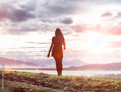 Junge Frau mit langen Haaren vor Bodenseepanorama im Gegenlicht