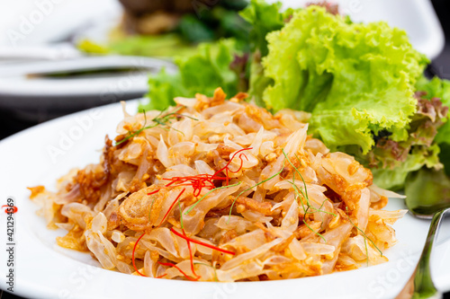 Fotografie Pomelo salad on spoon or Thai Yum Som O on white plate, closed up
