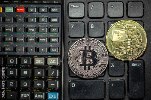 Criptomoedas Bitcoin em cima de teclado numérico de computador com calculadora científica. Tokens dourados e prateados em cima de botões. photo