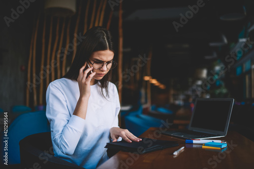Serious woman using smartphone for making call