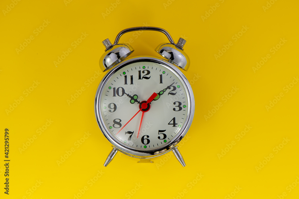 old mechanical alarm clock lies on a yellow background. old mechanical alarm clock lies on a yellow background.