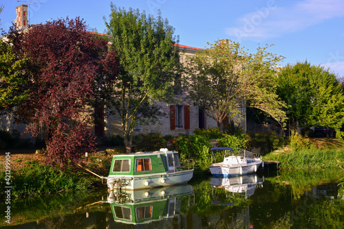 Deux bateaux sur la Sèvre Nortaise au soleil couchant à Damvix (85420), département de Vendée en région Pays de la Loire, France photo