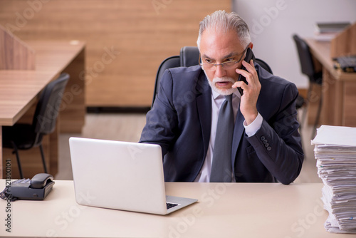 Old male employee unhappy with excessive work in the office