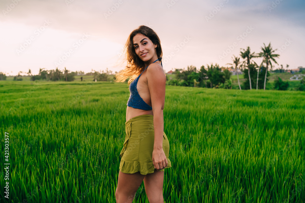 Half length portrait of carefree female tourist smiling at camera during leisure time for visiting rice fields in Vietnam, pretty woman in casual clothing posing near Indonesian nature landscape Half length portrait of carefree female tourist smiling at camera during leisure time for visiting rice fields in Vietnam, pretty woman in casual clothing posing near Indonesian nature landscape