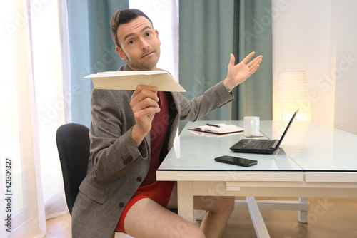 Konstfotografi Man in ridiculous and conformist attitude showing a paper airplane while suppose