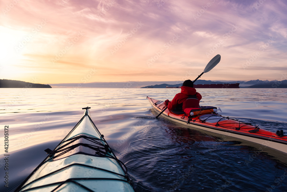 Naklejka premium Adventurous Man Sea Kayaking in the Pacific Ocean. Dramatic Colorful Sky Art Render. Taken in Jericho, Vancouver, British Columbia, Canada.