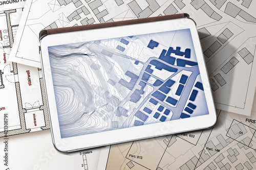 Imaginary cadastral map of territory with buildings and land parcel - concept image with a digital tablet - Note: the map background is totally invented and does not represent any real place