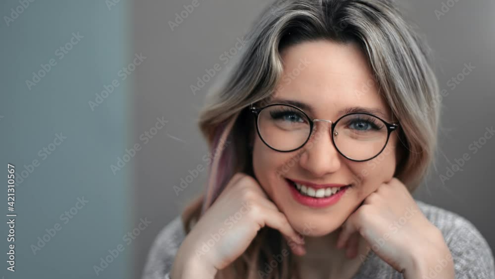 Closeup face of cute laughing feminine posing at gray wall. Shot on RED Raven 4k Cinema Camera Closeup face of cute laughing feminine posing at gray wall. Shot on RED Raven 4k Cinema Camera