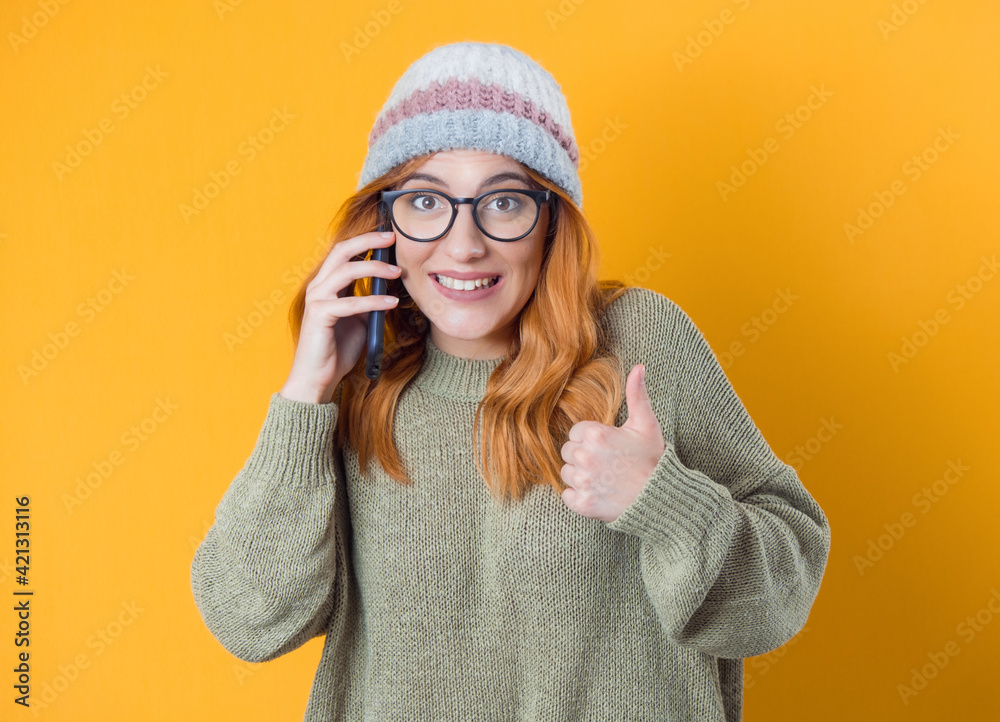 Φωτογραφία Yes,i am on the phone, happy trendy girl talks on the smartphone and gesturing like sign, isolated on yellow background