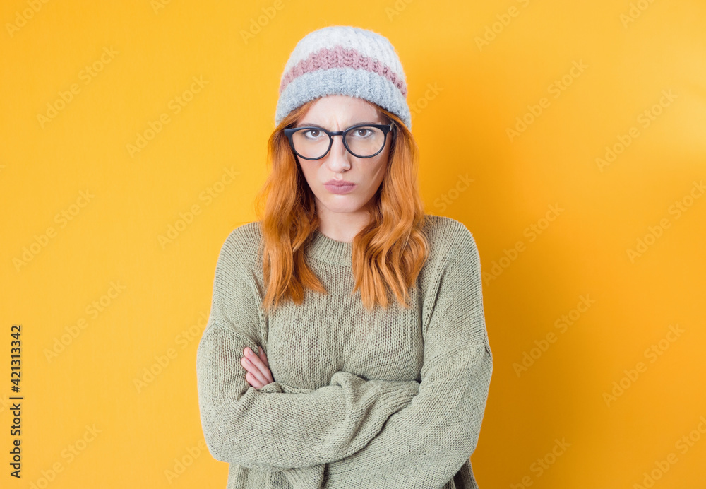 Frowned displeased young woman frowning her nose and lips standing with crossed arms, isolated over white background Frowned displeased young woman frowning her nose and lips standing with crossed arms, isolated over white background