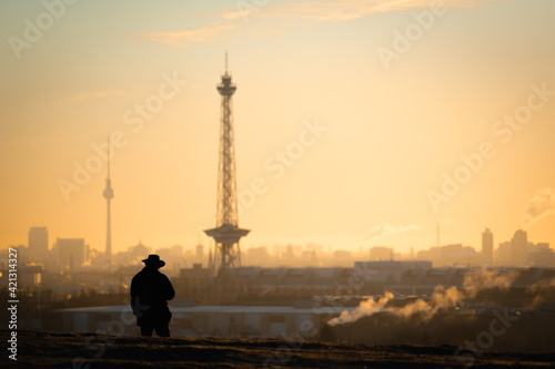 man overlooking the sunrise over the city of berlin