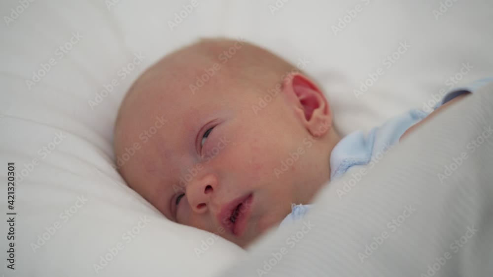 newborn baby infant sleeping in bed closeup, face of 3-week-old little boy lying in crib newborn baby infant sleeping in bed closeup, face of 3-week-old little boy lying in crib