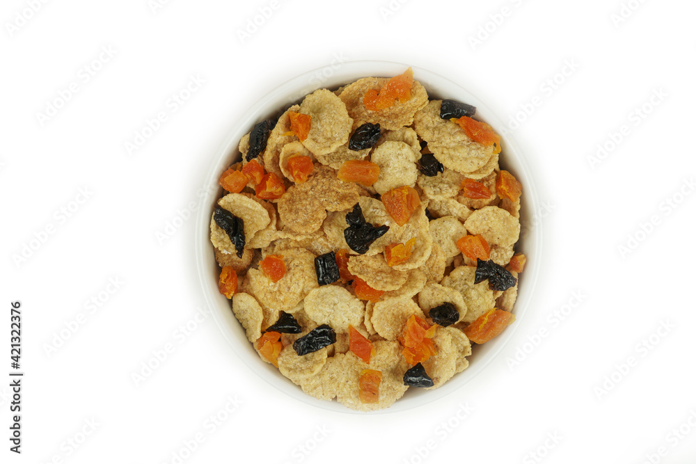 A bowl of cornflakes with dried apricots and prunes, top view. Isolated A bowl of cornflakes with dried apricots and prunes, top view. Isolated
