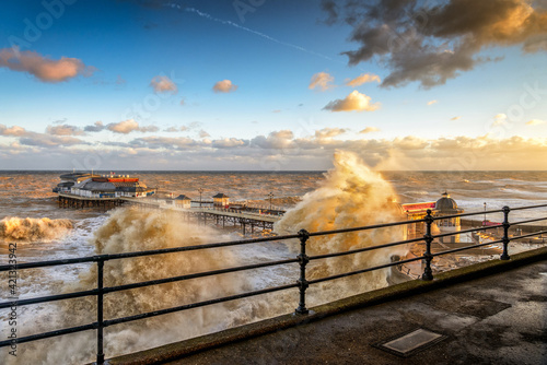 Fotografia Rough seas batter the North Norfolk Coast, with waves breaking over the promenad