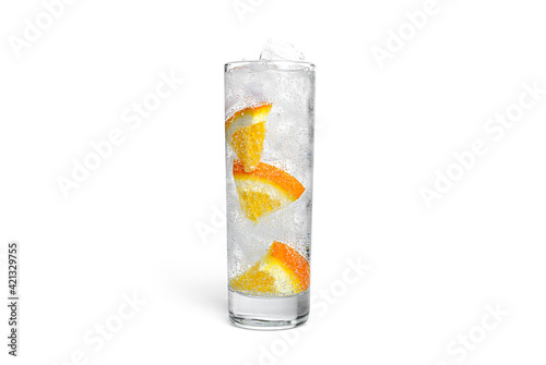 Orange lemonade with ice in a clear glass isolated on a white background.