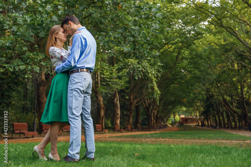 Happy romantic moments of lovely couple hugging in the park whil