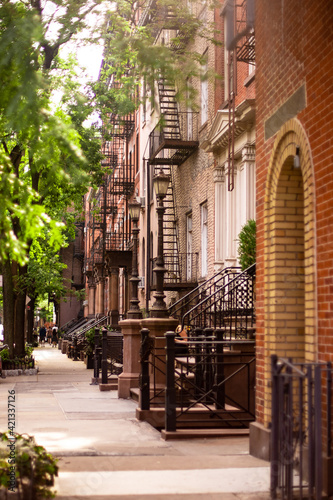 Street scene of residential neighborhood with a row of buildings seen from New York City Manhattan