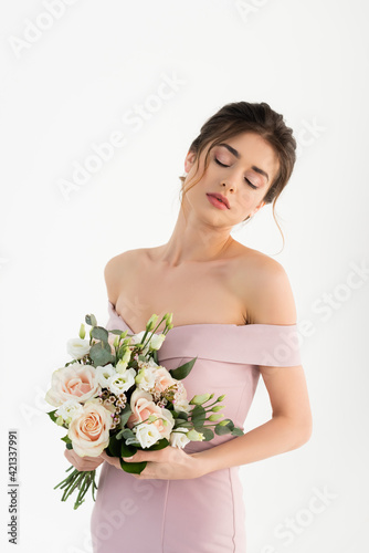 sensual woman in dress, with naked shoulders, holding wedding bouquet isolated on white