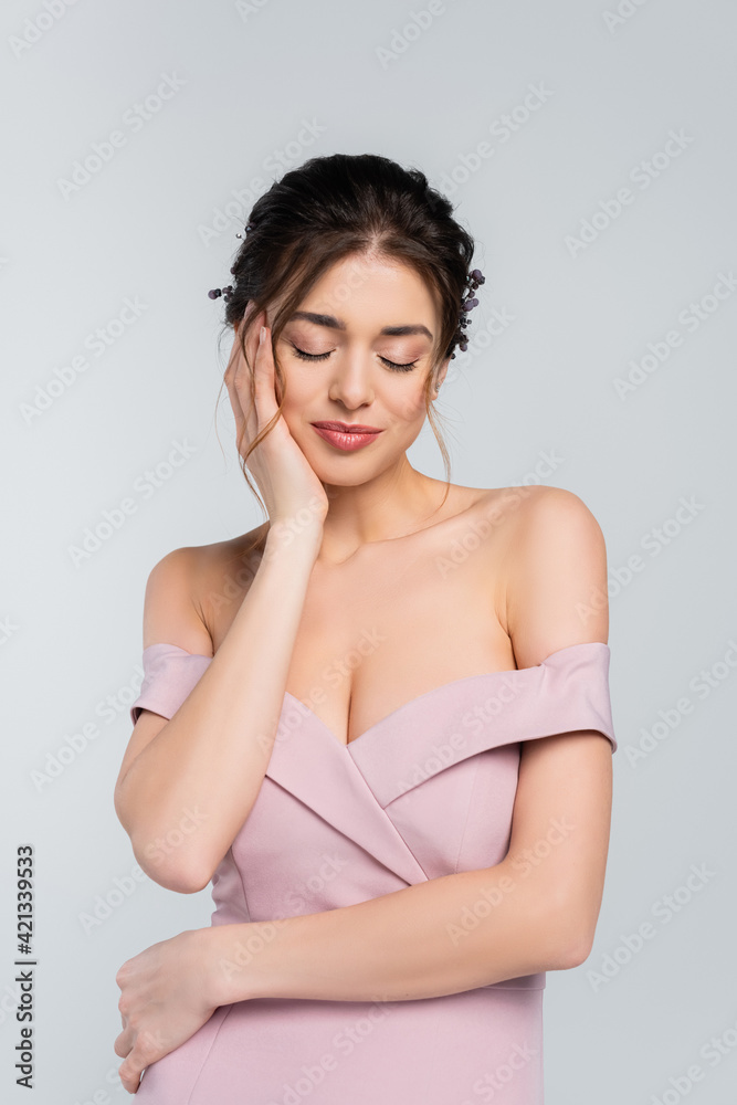 charming woman touching face while posing with closed eyes isolated on grey charming woman touching face while posing with closed eyes isolated on grey