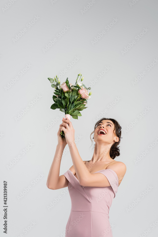 excited bride in pink dress throwing wedding bouquet isolated on grey excited bride in pink dress throwing wedding bouquet isolated on grey