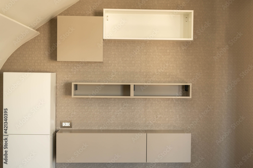 Hanging cabinets and shelves in the interior of a residential building in different shades of gray. Hanging cabinets and shelves in the interior of a residential building in different shades of gray.