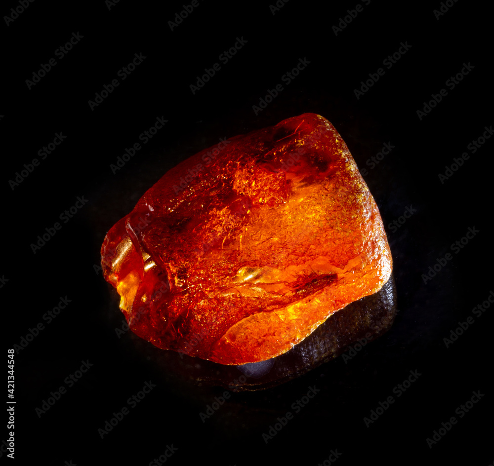 Shiny yellow gold amber stone isolated on black background. Found near Kaliningrad city, Baltic sea, Russia. For cosmetic or medicine articles, mineralogy websites, natural science museum wall chart Shiny yellow gold amber stone isolated on black background. Found near Kaliningrad city, Baltic sea, Russia. For cosmetic or medicine articles, mineralogy websites, natural science museum wall chart