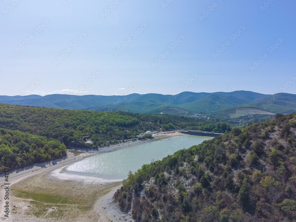 aerial view of mountain lake surrounded by fir trees, top view of lakes in wooded mountains