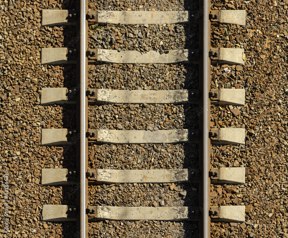 Seamless railroad Pattern, backdrop with space for text. Top view. Shiny iron rails and concrete sleepers, coupled with powerful bolts on stony ground, fortified rubble overgrown with weeds green Seamless railroad Pattern, backdrop with space for text. Top view. Shiny iron rails and concrete sleepers, coupled with powerful bolts on stony ground, fortified rubble overgrown with weeds green