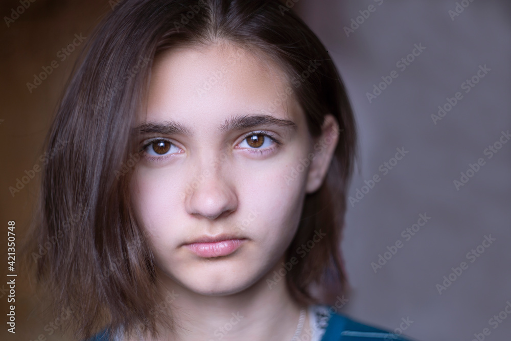 Close-up of the face of a beautiful young brunette girl with dark brown eyes. Bob haircut, short hair. Close-up of the face of a beautiful young brunette girl with dark brown eyes. Bob haircut, short hair.
