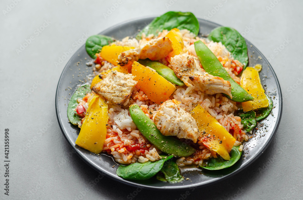 Cooked chicken breast pieces with peppers, sugar snap peas, and baby leaf spinach in a spicy sweet and sour sauce with fragrant rice Cooked chicken breast pieces with peppers, sugar snap peas, and baby leaf spinach in a spicy sweet and sour sauce with fragrant rice