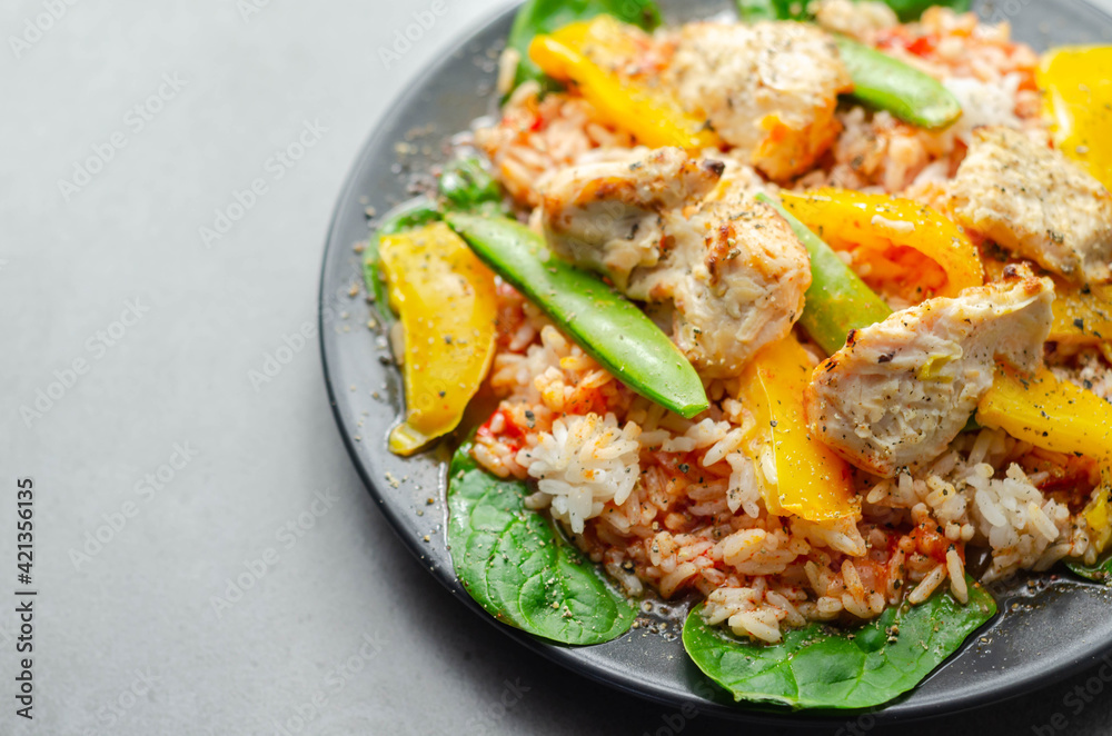 Cooked chicken breast pieces with peppers, sugar snap peas, and baby leaf spinach in a spicy sweet and sour sauce with fragrant rice Cooked chicken breast pieces with peppers, sugar snap peas, and baby leaf spinach in a spicy sweet and sour sauce with fragrant rice