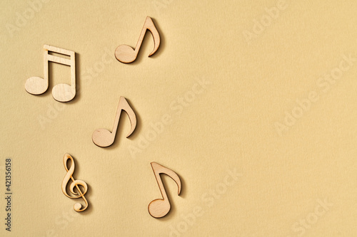 Wooden musical notes on beige background with copy space