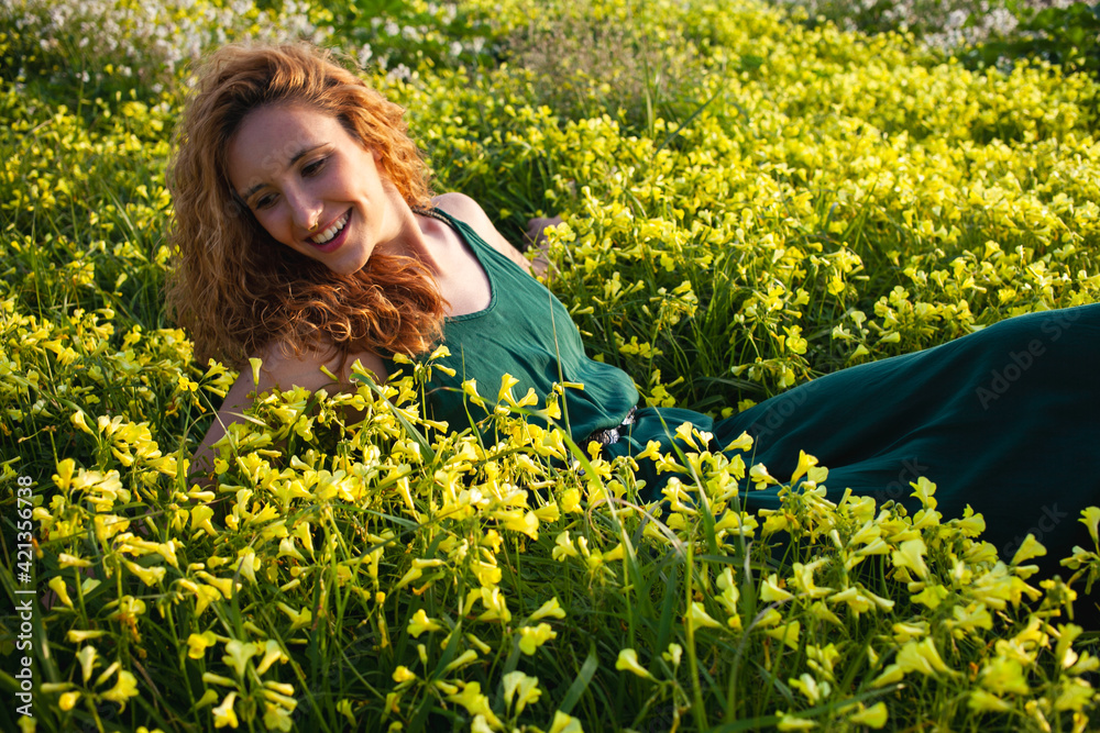 Young redhead girl in a beautiful field of yellow flowers in a green vintage dress Young redhead girl in a beautiful field of yellow flowers in a green vintage dress