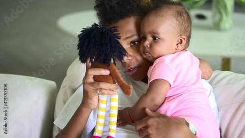 Older biracial brother hold infant sister and use doll to play with her. Spbd preteen boy talk
