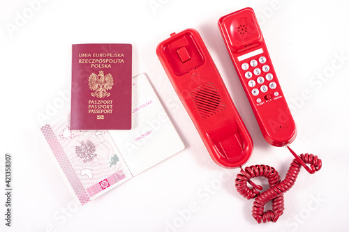 Passport and old red telephone camera. Voice communication accessories and personal documents.