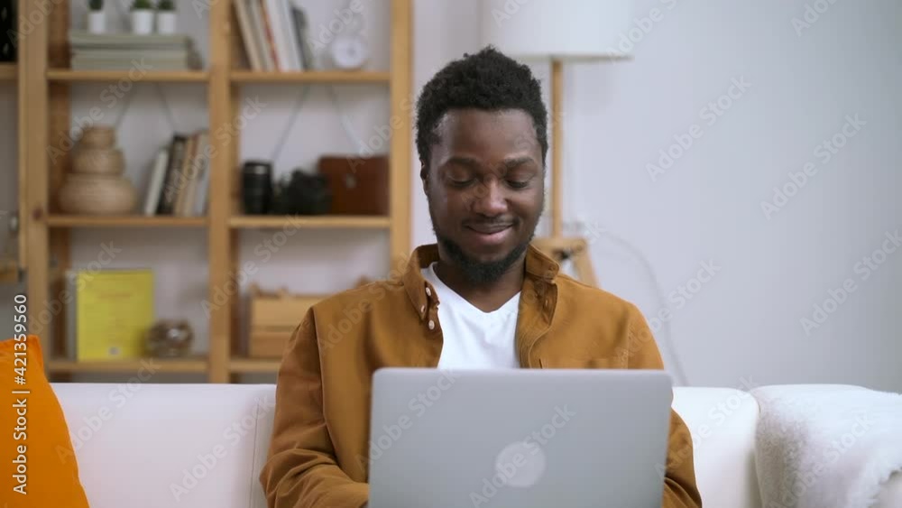 African man working at home on computer on background of interior Spbas. African man working at home on computer on background of interior Spbas.