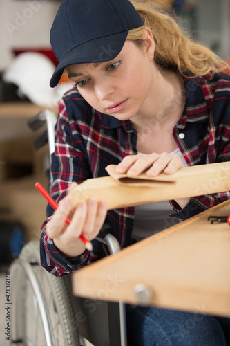 a disabled female is sanding wood