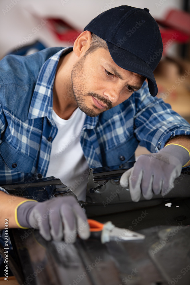the bodyworker repairs panel using pliers the bodyworker repairs panel using pliers